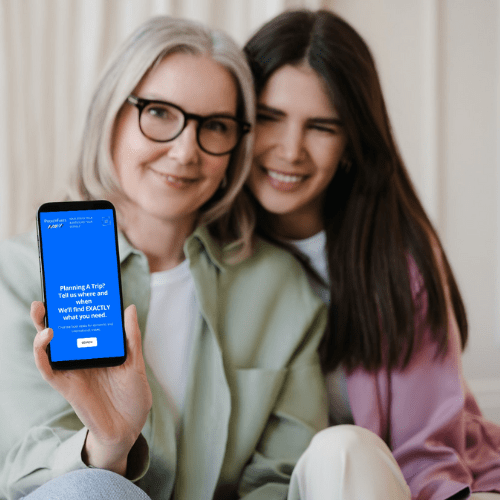 Mother and daughter showing phone screen with pocketfares website homepage opened